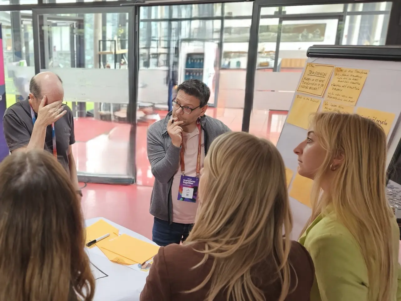 Eine Gruppe diskutiert im World Café konzentriert an einem Stehtisch.
